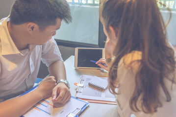 Young lady discussing with her partner showing data on tablet