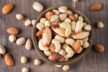 Healthy mix nuts on wooden background. Almonds, hazelnuts, cashews, peanuts, pistachios, Brazil nuts