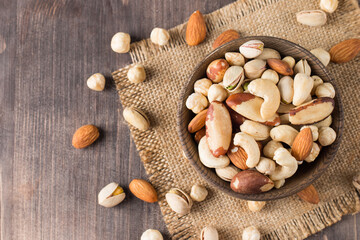 Healthy mix nuts on wooden background. Almonds, hazelnuts, cashews, peanuts, pistachios, Brazil nuts