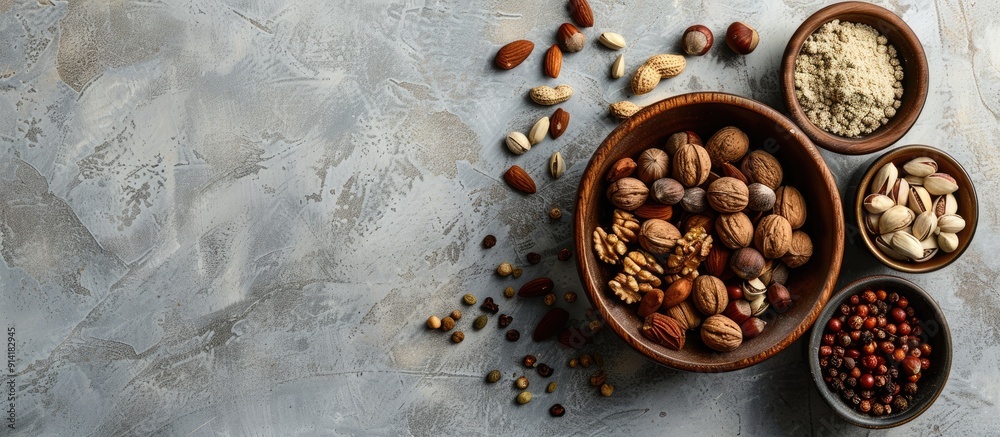 Poster Top view of various spices and nuts in a bowl on a textured light gray table with room for text in the image. Creative banner. Copyspace image