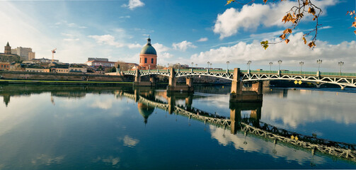 Panoramic View of Saint Pierre Bridge and La Grave Hospital Reflecting in the Garonne River at Sunrise, Bathed in Golden Sunrise Light with a Clear Blue Sky, Toulouse