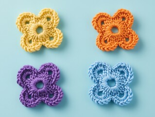 Colorful knitted flowers on blue background for crafting concept