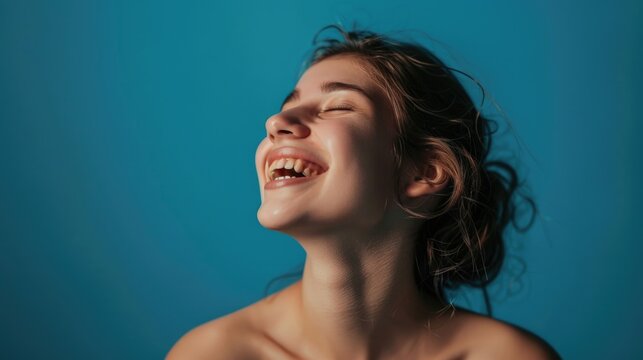 Laughing with mouth open, joyful expression on face.