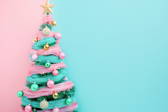 Decorated Christmas tree onpastel green and pink background