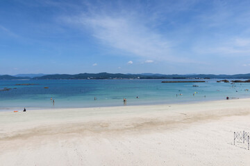 good weather greenish blue sea and beach withe people swimming in the sea and playing on the sad taken in Ise, Mia, Japan