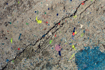 A vividly colored and chaotic paint splatter on a textured surface that captures the essence of abstract expressionism.