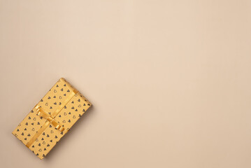 Gift box on beige background from above. Flat lay, top view.