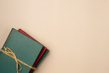 Stack of books on a beige background. Leisure concept, reading a book. Copy space. Flat lay, top view