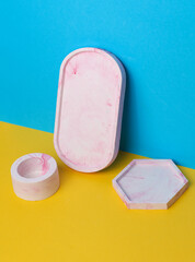 Decorative plaster trays on blue yellow background. Stands for candles, organizers for cosmetics or jewelry.