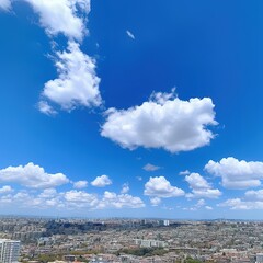 A panoramic cityscape under a bright blue sky with fluffy white clouds.