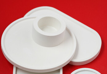 Decorative plaster trays on red background. Stands for candles, organizers for cosmetics or jewelry.