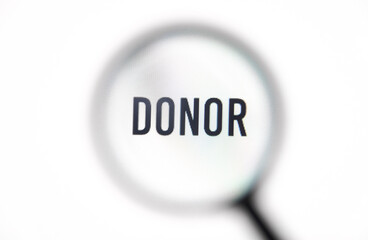 Word donor on screen through magnifying glass close-up