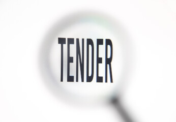 Word tender on screen through magnifying glass close-up