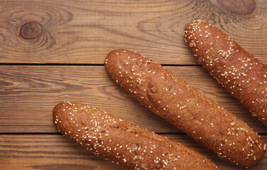 Rye buns, mini baguettes on a wooden background