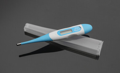 Electronic thermometer with plastic case on black background close up