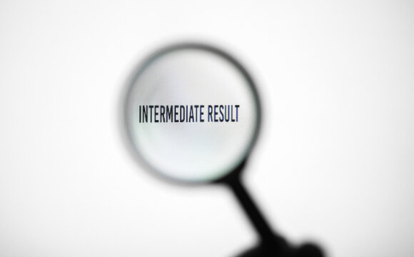 Phrase intermediate result on white screen through a magnifying glass.