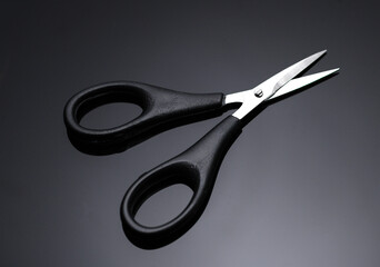 Beard scissors on black background close up