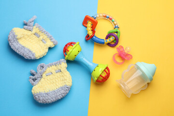 Toys and shoes for newborns on a blue-yellow background