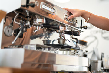 Fresh coffee dropping from the coffee making machine down into the cup. Drink and object, close-up and selective focus.