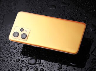 Smartphone in water drops on a black background
