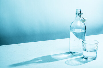 Clear glass water bottle with glass, cyan tinted

