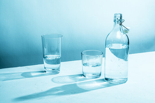 Clear glass water bottle with glass, cyan tinted

