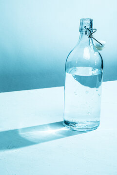 Clear glass water bottle with glass, cyan tinted

