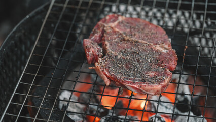 Sizzling Steak Over Charcoal, A seasoned steak sits directly on the grill over hot, glowing charcoal, showcasing the intense heat and the start of the perfect sear