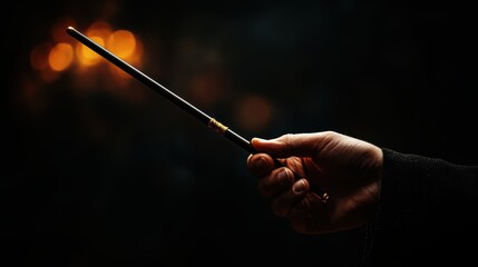 A hand holding a magical wand against a dark, mystical background, evoking themes of magic, mystery, and fantasy in a cinematic setting.