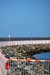 Bollard on the pier with twisted ropes of green colour.