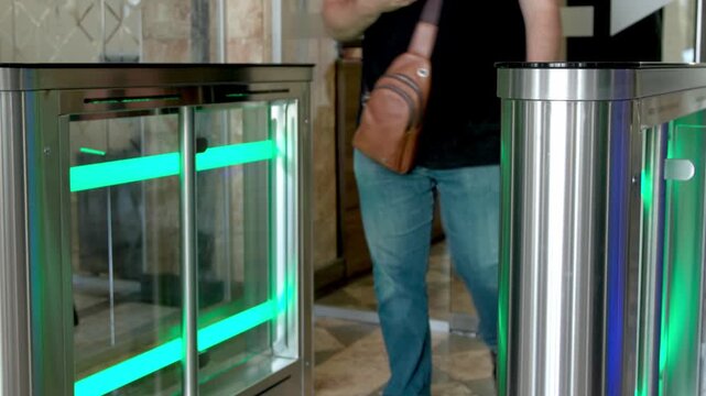 A businesswoman and businessman use their personal access cards to enter a sleek modern office. Ideal for showcasing office security, professional environments, and cutting-edge workplace technology.