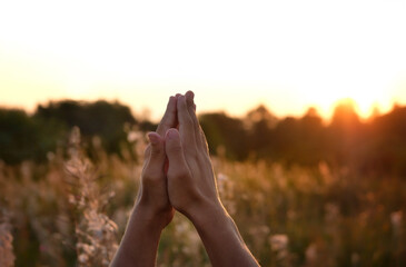 man's hands in pray and worship outdoor, abstract sunny natural background.  symbol of Belief in God, Blessing, Repent, Help, hope, faith, devotion of God. Religion, spirituality concept 
