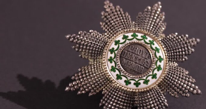 Detailaufnahme Rotation eines alten Ordens vor schwarzem Hintergrund