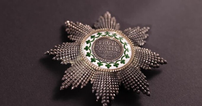 Detailaufnahme Rotation eines alten Ordens vor schwarzem Hintergrund