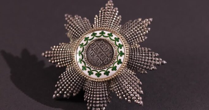 Detailaufnahme Rotation eines alten Ordens Auszeichnung Ehrung vor schwarzem Hintergrund