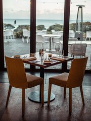 Vertical footage of dining table near teras located next to the beach.