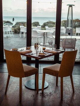 Vertical footage of dining table near teras located next to the beach.