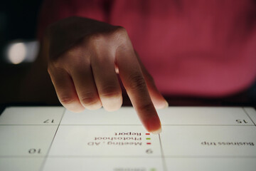 Close-up shot of hand interacting with touchscreen device during business presentation in dark...