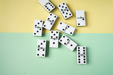 White domino blocks on yellow and green background. High angle shot.
