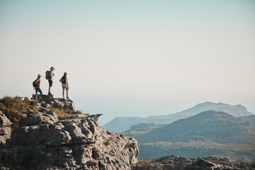 Friends, mountain and hiking on cliff outdoor for fitness travel, adventure space or backpack...