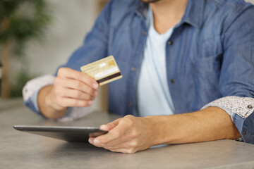 man making an online purchase on a digital tablet