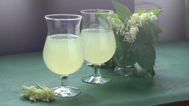 Carbonated elderflower drink. Flower summer kvass in glasses. Sparkling homemade cold water.