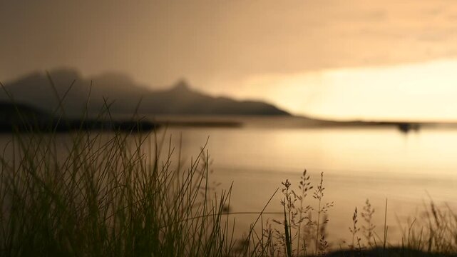 Dramatic evening storm clouds at stunning evening over the beach at Mjelle in Northern Norway pouring rain over the bay