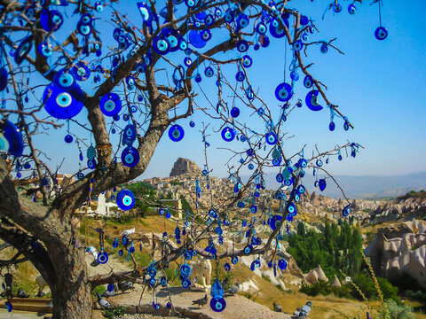 G&ouml;reme National Park and the Rock Sites of Cappadocia seen seen through the tree on which the nazar (Turkish evil eye) hangs