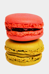 Pastries, desserts and sweets. Close-up of a red french raspberry macaron and a green pistachio macaroons isolated on a white background. Macro photograph.