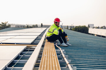 Engineer service check installation solar cell on the roof of factory. Engineers walking on roof inspect and check solar cell panel. Engineer working inspection installation solar cell on the roof