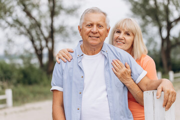 Happy Senior Couple Embracing Outdoors, Smiling and Enjoying Time Together