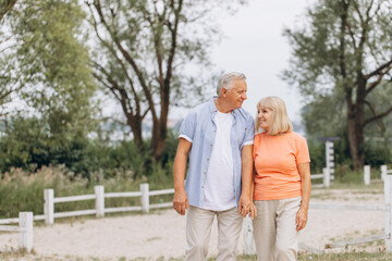 Fototapeta premium Happy Senior Couple Walking Hand in Hand in a Park