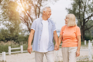 Obraz premium Happy Senior Couple Walking Together in a Park, Enjoying Leisure Time Outdoors