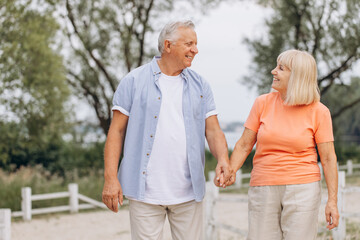 Happy Senior Couple Walking Together in a Park, Enjoying Leisure Time Outdoors